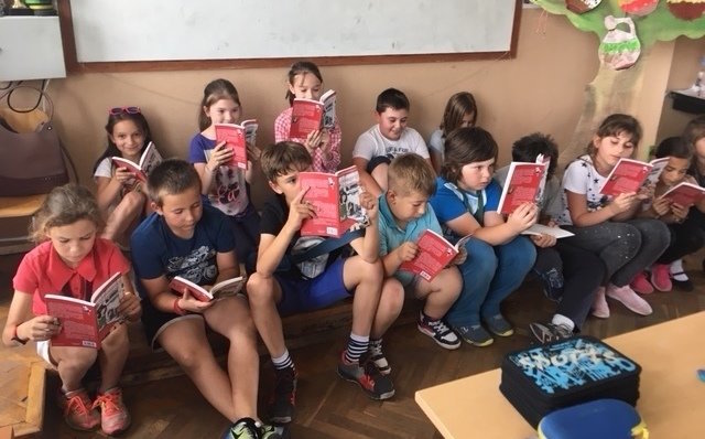 Деца четата книгата "Мая и концертът на талантите"
